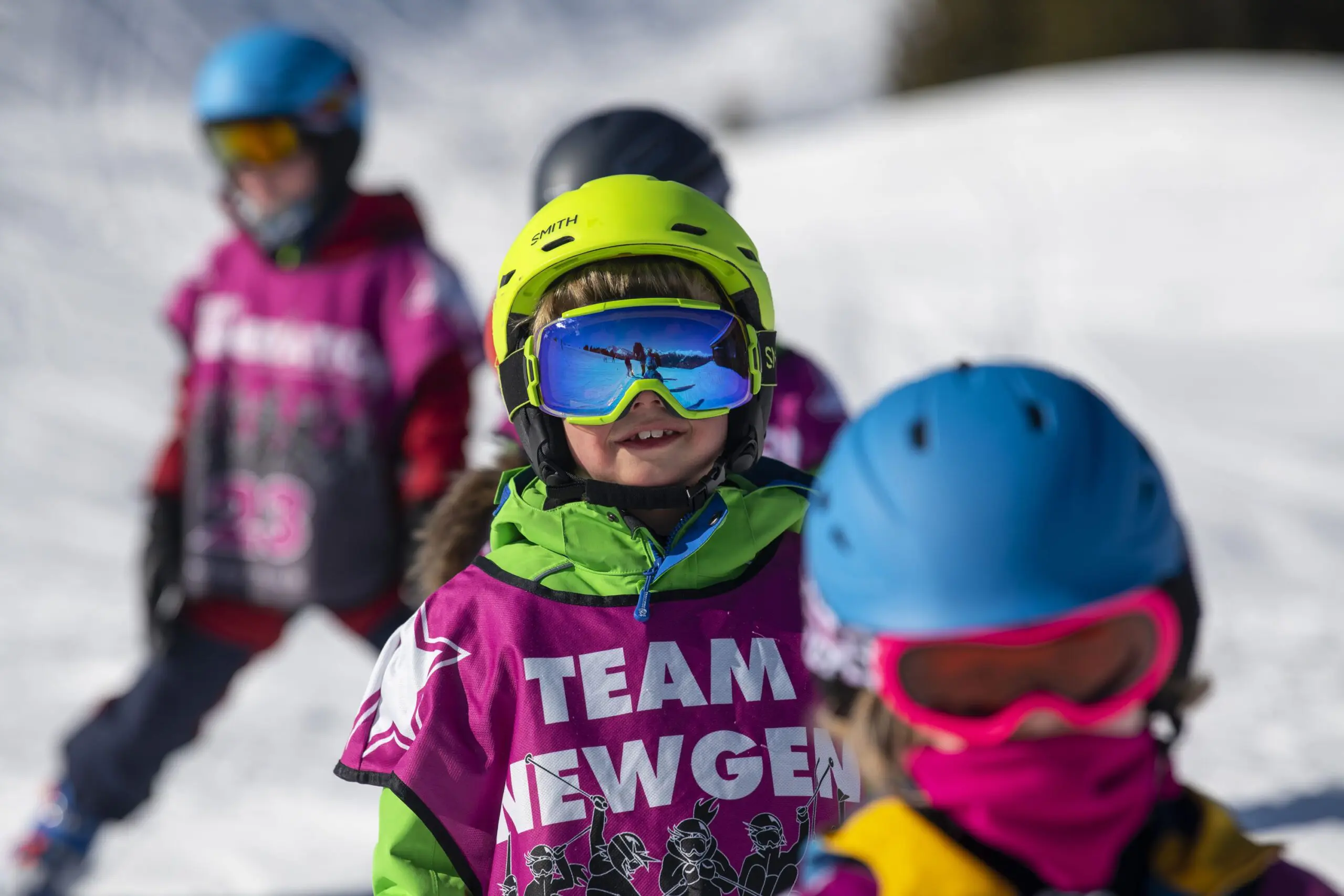 Smiling boy in ski school with green helmet