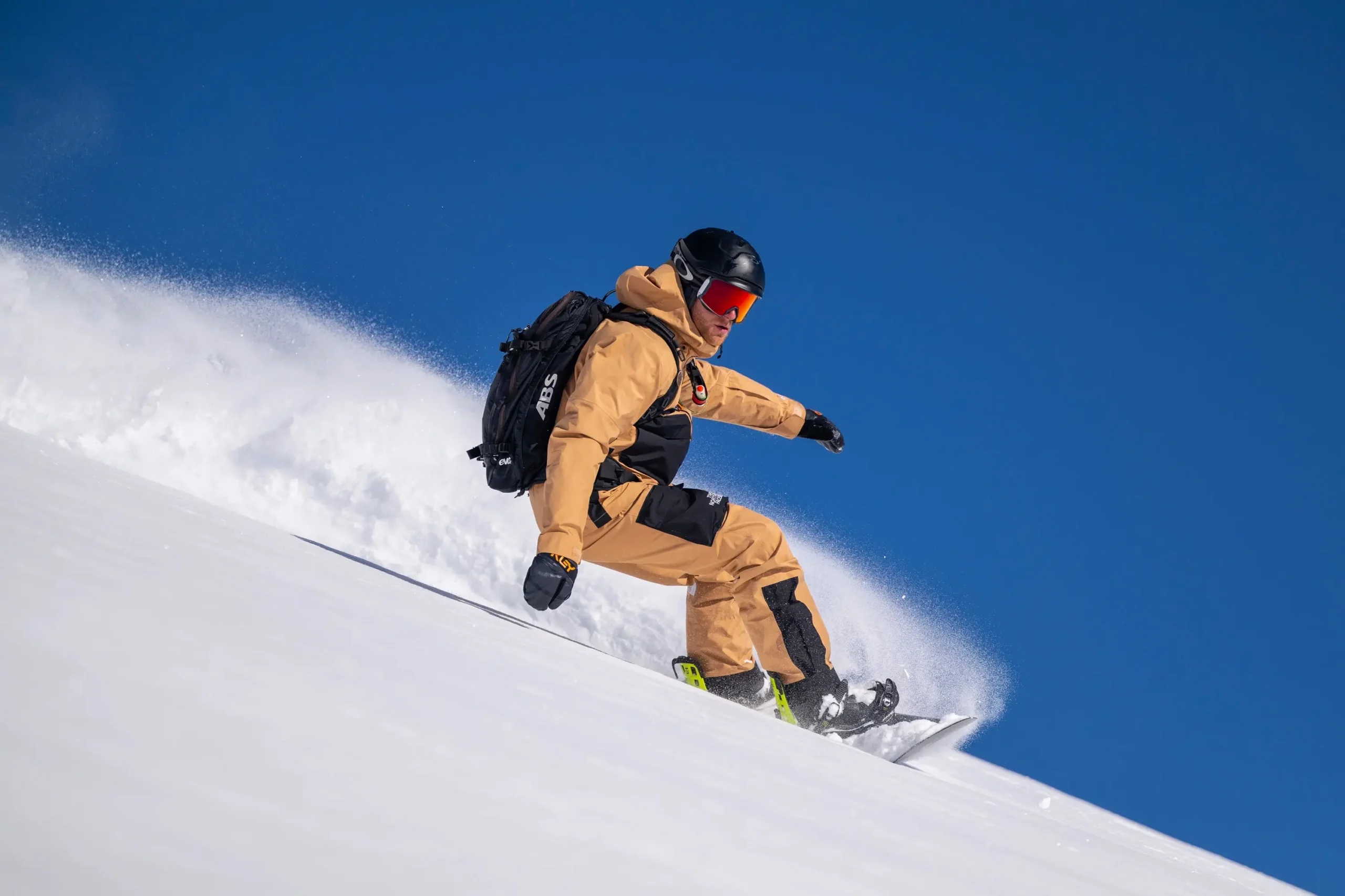 Un moniteur de snowboard faisant une virage hors-piste