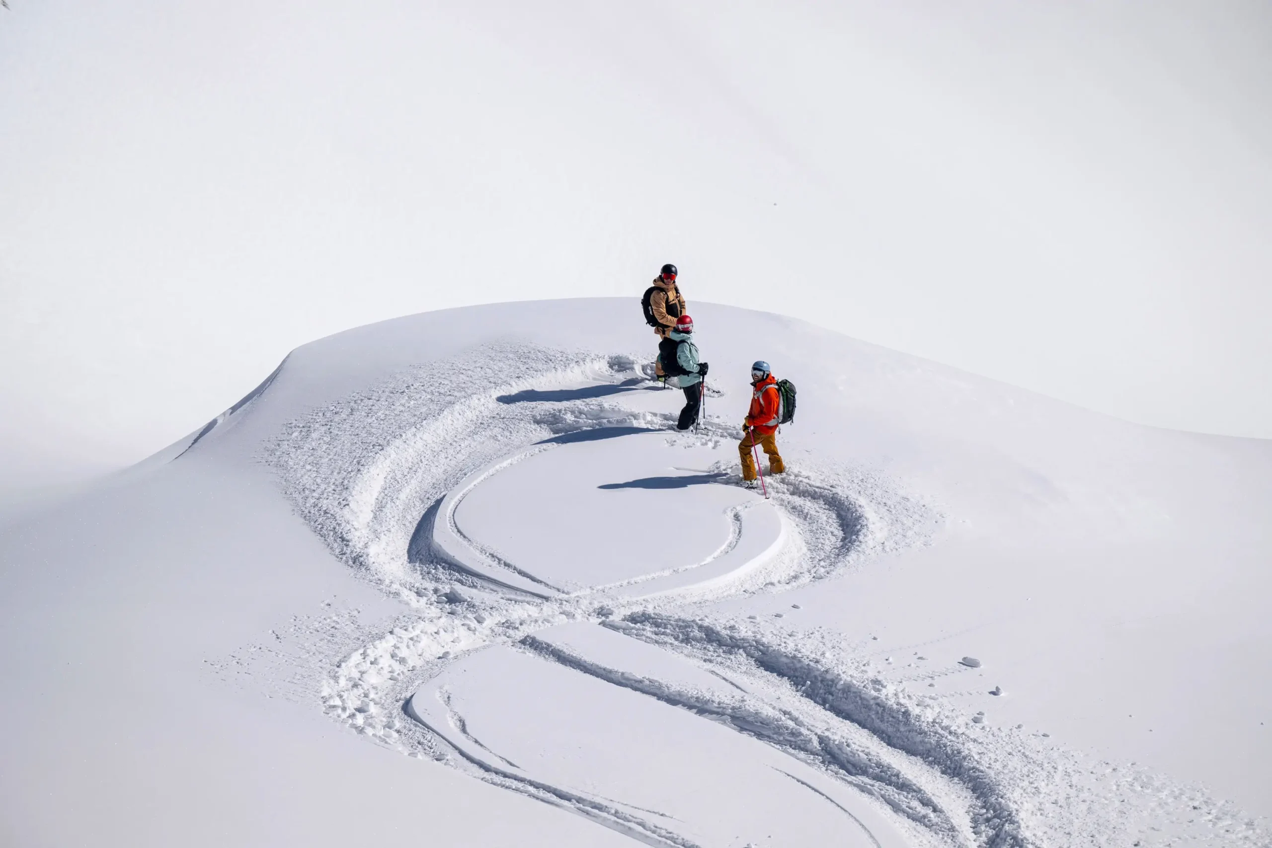 Skiers looking back up a slope on an off-piste course