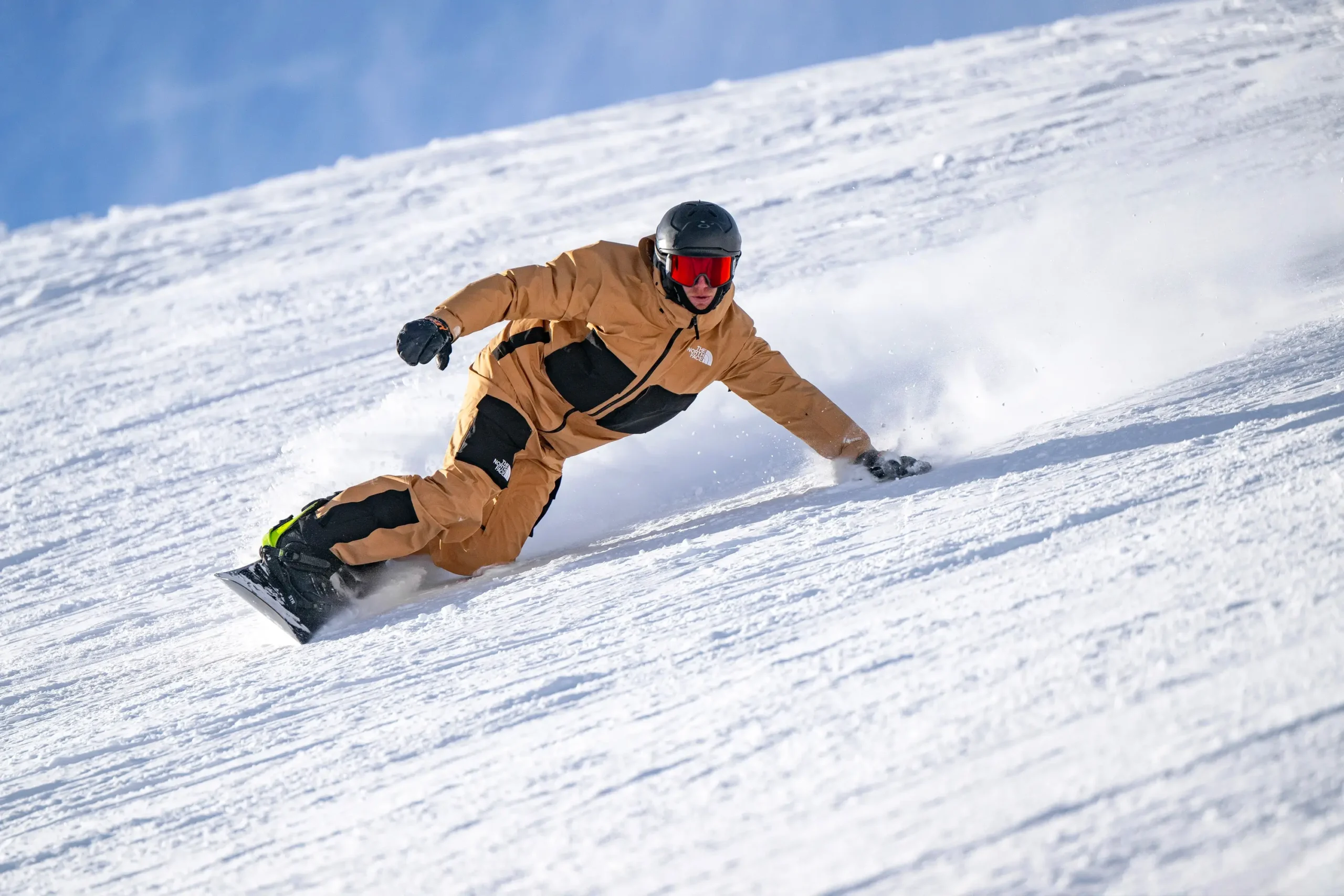 Un moniteur de snowboard effectuant un virage sculpté