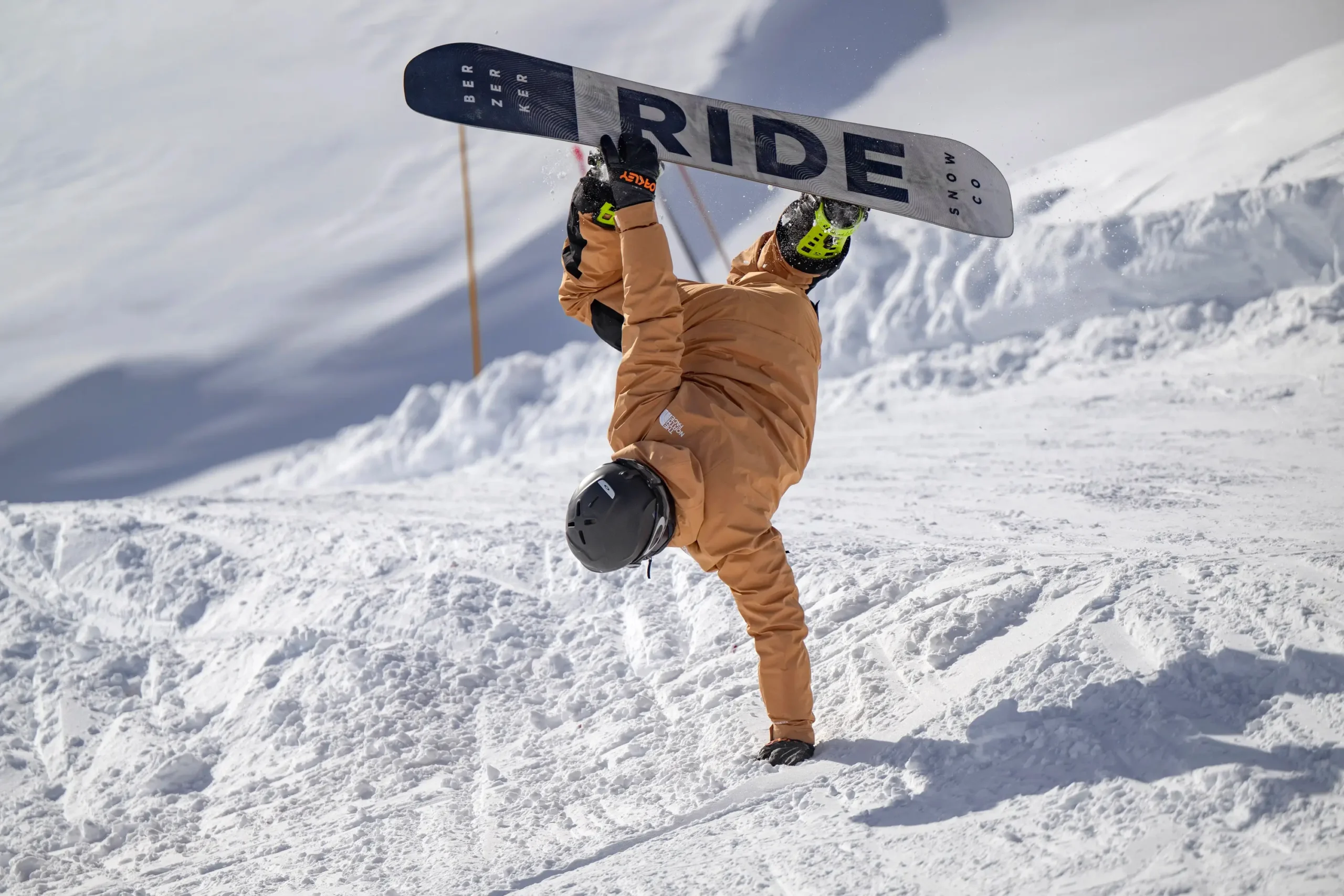 Un moniteur montre comment faire une figure lors d'une leçon privée de snowboard.