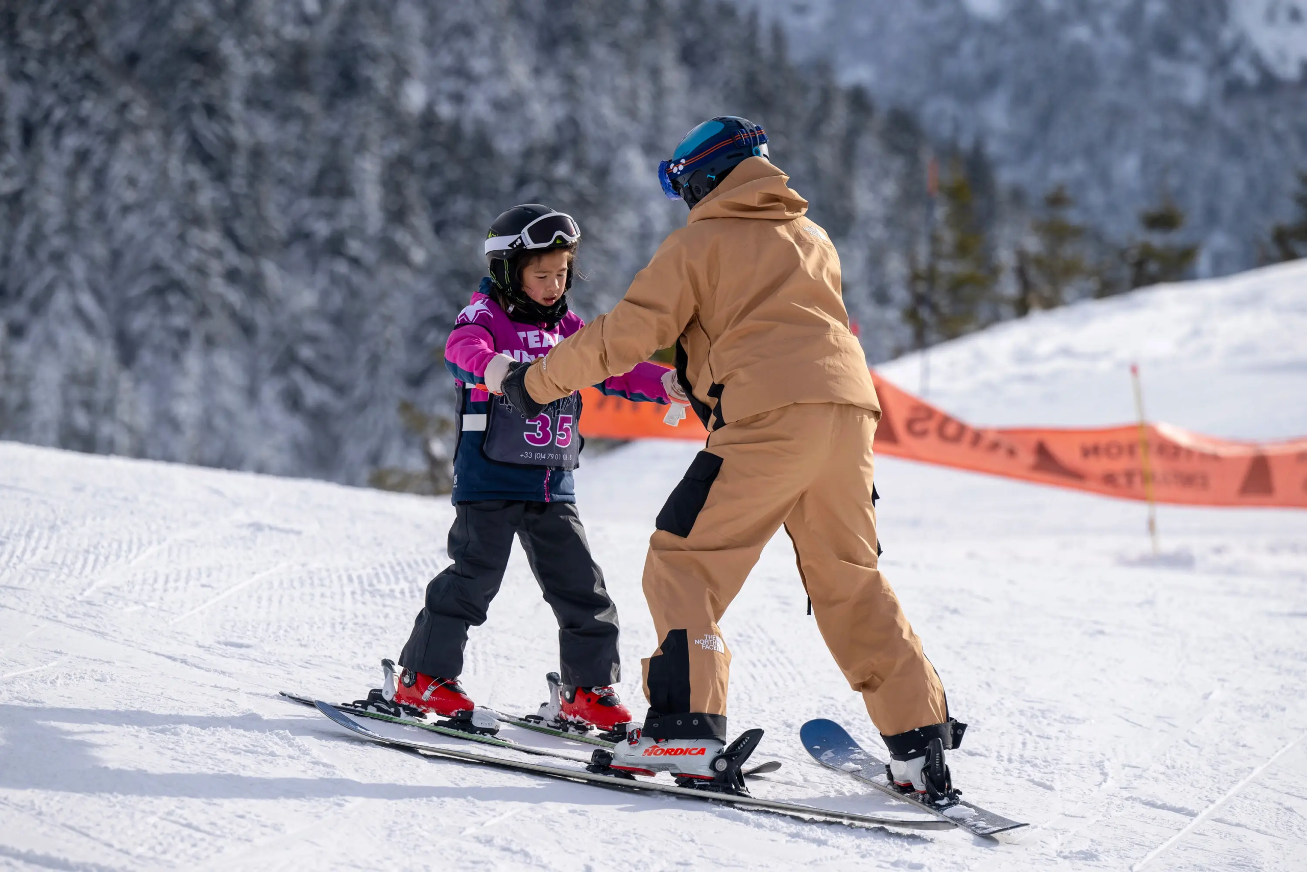 Un enfant guidé par un moniteur de ski à Méribel